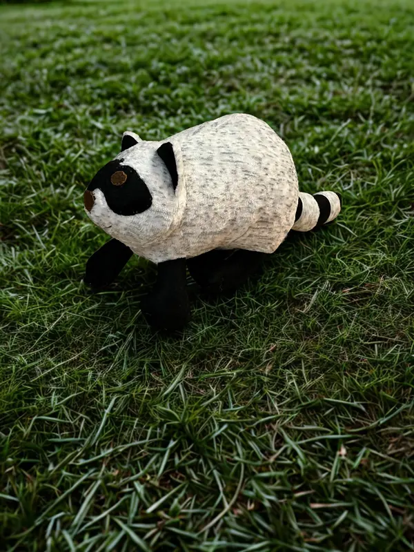 Handmade raccoon in the grass